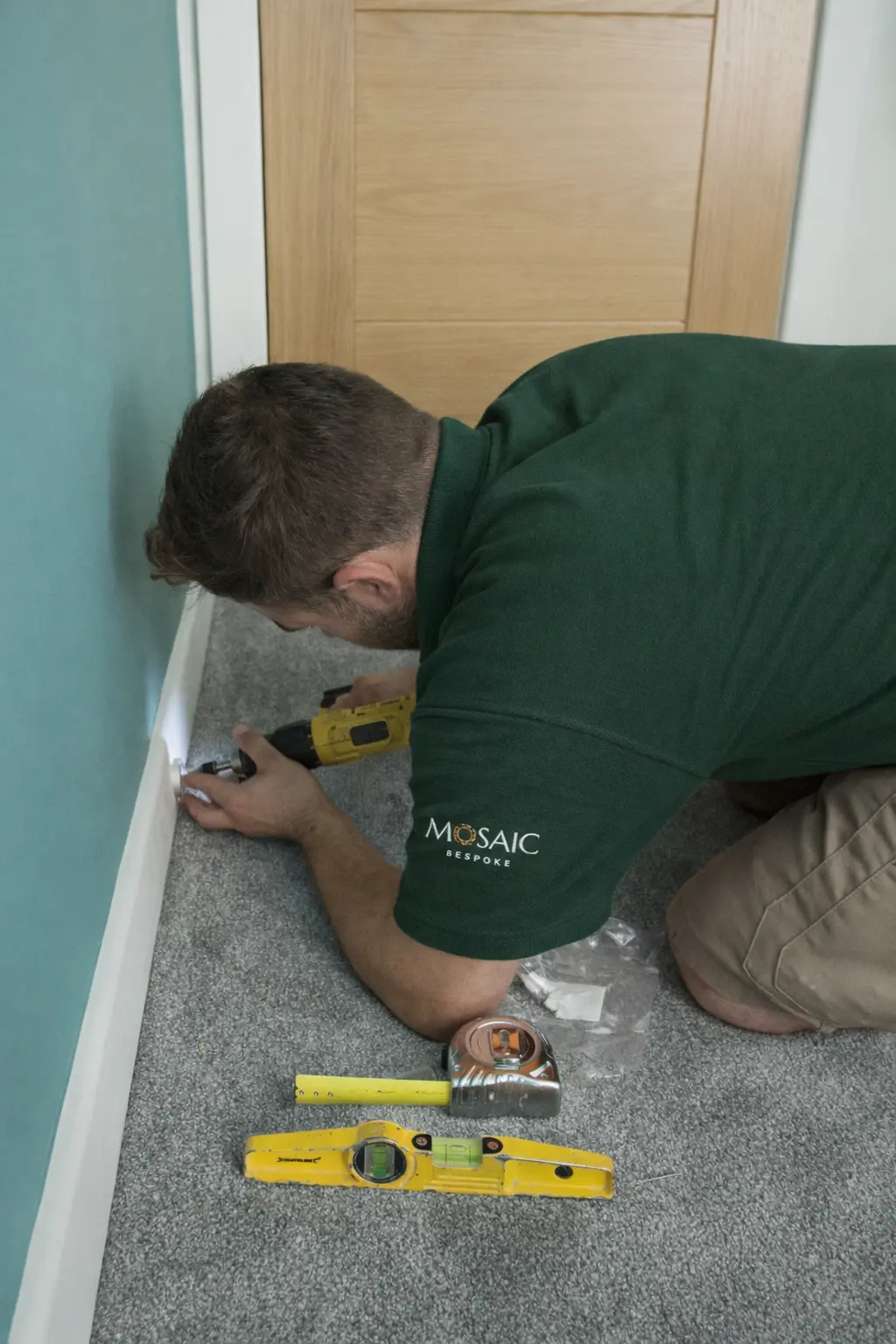 Mosaic Bespoke tradesperson fitting carpet edge trim